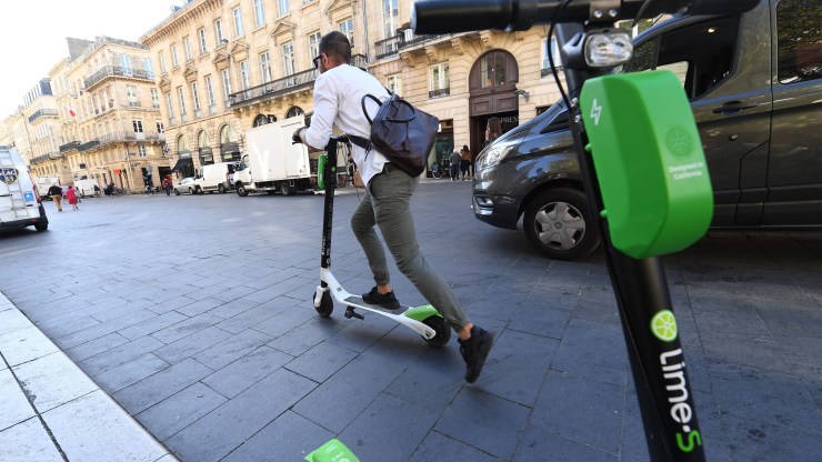 A man rides a Lime electric scooter on September 27, 2018 in the southwestern French city of Bordeaux