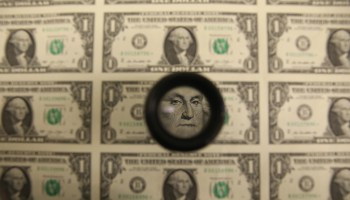 A magnifying glass is used to inspect newly printed dollar bills at the Bureau of Engraving and Printing in Washington, D.C..