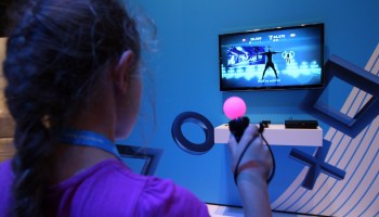 A girl plays a dancing game on a Playstation 3 video console