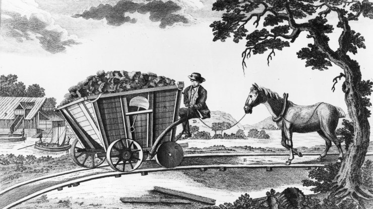 A Newcastle coal wagon of 1773 from "A Picture History of Railways" by C. Hamilton Ellis, showing a filled wagon with flanged wheels and a horse following behind on a down-gradient railway line.