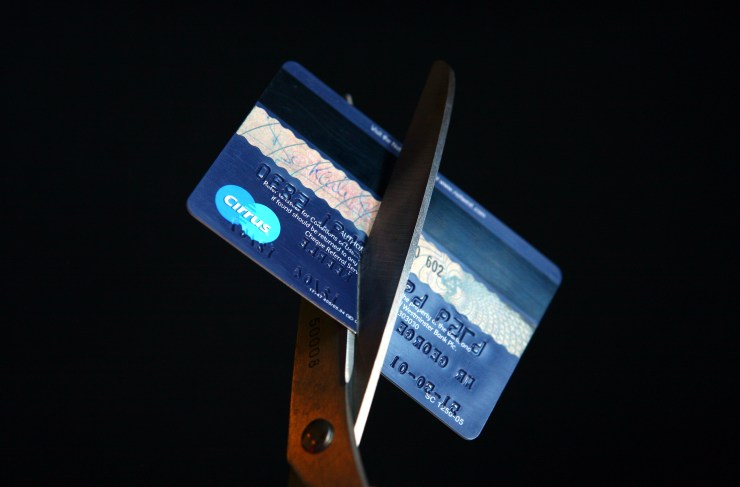 In this photo illustration a credit card is cut in half by a pair of scissors.