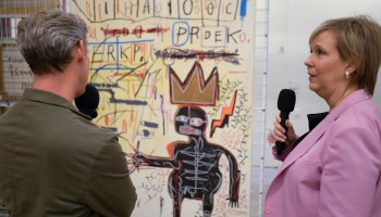 Kai talks to Joanne Heyler, founding director of Broad, in front of Jean-Michel Basquiat's painting, "With Strings Two."