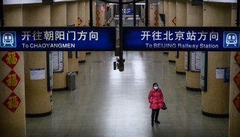 A woman wears a protective mask as she waits on an empty subway platform during the evening rush hour on Feb. 3 in Beijing.