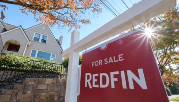 A Redfin real estate yard sign is pictured in front of a house for sale on Oct. 31, 2017 in Seattle, Washington.