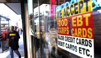 A sign in a market window advertises the acceptance of food stamps in New York City.
