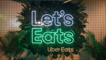 An Uber Eats neon sign that reads "Let's Eats."