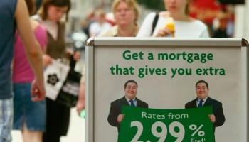 People walk by a mortgage advertising stand in 2003.