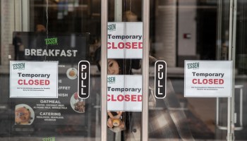 A woman hangs a sign in a restaurant due to closures in the wake of the COVID-1 on March 17 in New York City.