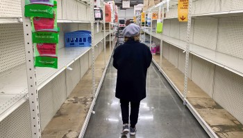 A shopper walks past empty shelves normally stocked with soap, sanitizer, paper towels and toilet paper at a Smart & Final grocery store, March 7 in Glendale, California.