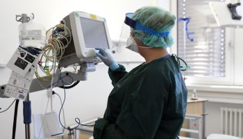 A nurse checks medical surveillance equipment. The new COVID-19 tracking site went live this week, but the transition could prove difficult for hospitals.