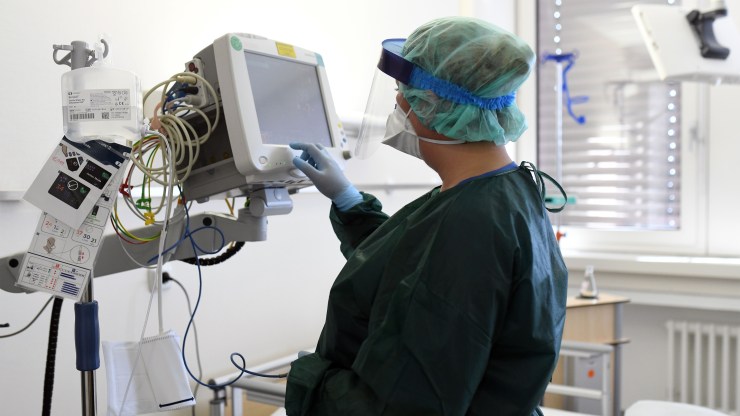 A nurse checks medical surveillance equipment. The new COVID-19 tracking site went live this week, but the transition could prove difficult for hospitals.