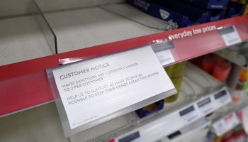 A picture shows a sign on empty shelves alerting customers to limited sales of antibacterial hand washes and hand sanitizer
