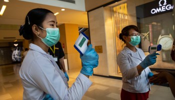 Health workers wear masks and are ready to check temperatures when shoppers arrive at a Yangon, Myanmar, shopping mall on Monday.