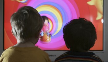 Two young kids watching TV