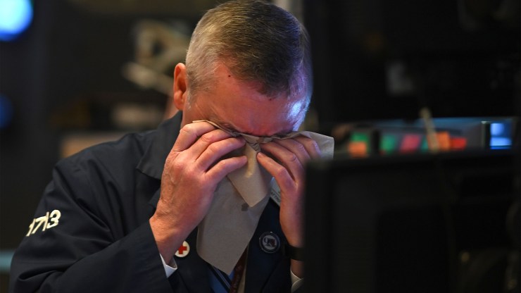 A trader wipes his face as he works during the closing bell at the New York Stock Exchange on March 3.