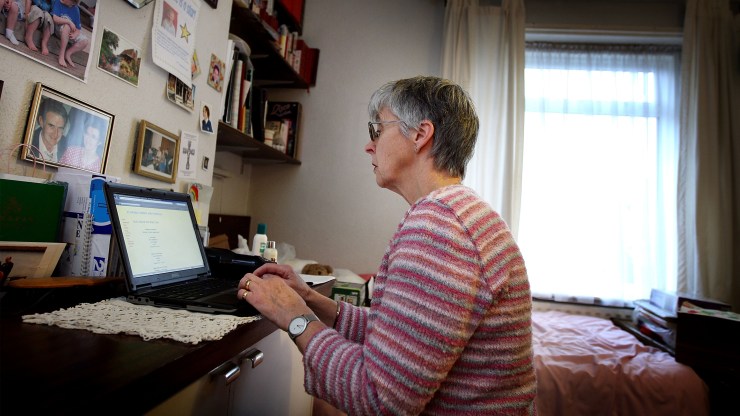 A woman uses a laptop at her home desk