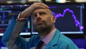 A trader on the floor of the NYSE looks distressed on March 9