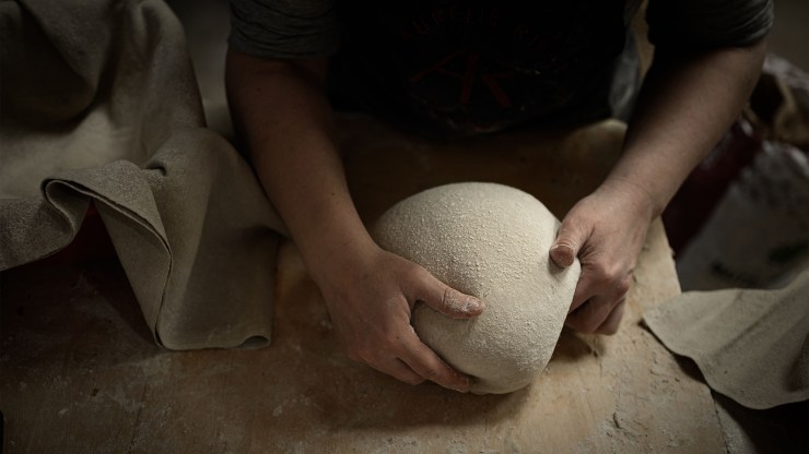A person kneading bread dough