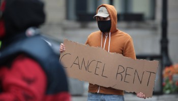 A demonstrator in Chicago on Thursday calls for rent and mortgage payments to be suspended to help those who have lost their income due to the coronavirus.