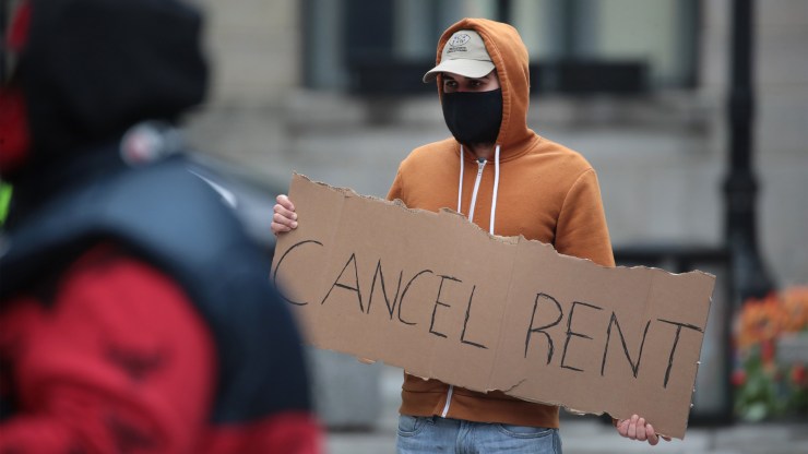 A demonstrator in Chicago on Thursday calls for rent and mortgage payments to be suspended to help those who have lost their income due to the coronavirus.
