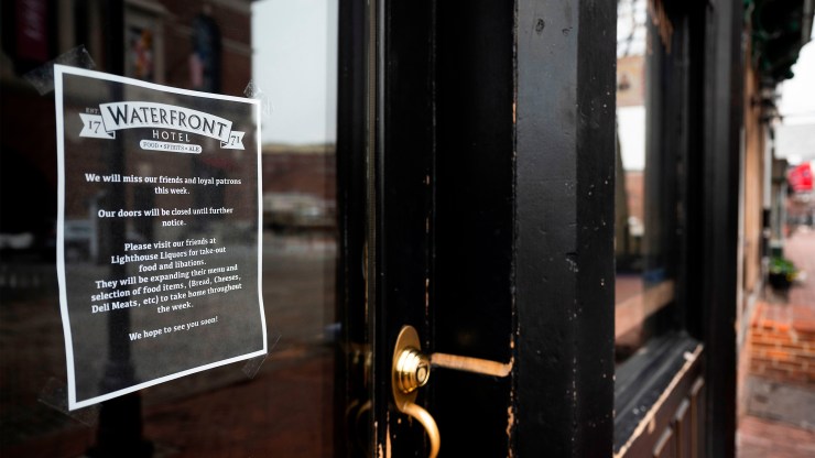 A note on the door of the Waterfront Hotel lets customers know they will be closed in Baltimore, Maryland, on March 19