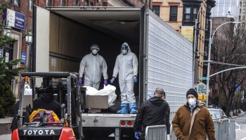 Medical workers remove a body from a refrigerator truck outside of the Brooklyn Hospital on March 31.