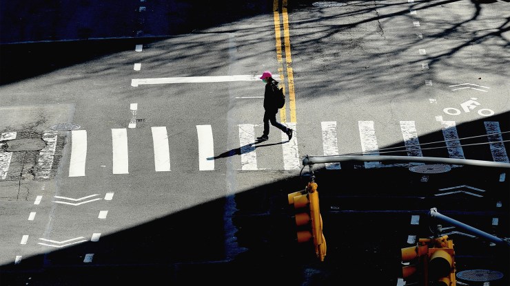 A person crosses the street on March 27 in New York City