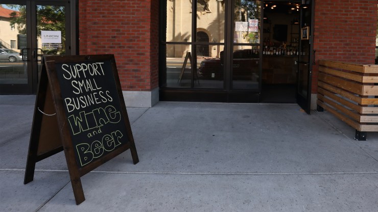 A sign reading Support Small Business is displayed outside of a restaurant on March 26 in Arizona.