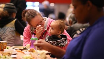 A woman feeds a baby at a Thanksgiving meal hosted by the Bay Area Rescue Mission in Richmond, California, in 2015. Photo by Justin Sullivan/Getty Images