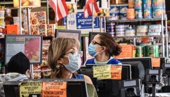 Cashiers wearing protective masks work in a grocery store in Brooklyn on April 2.