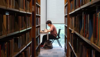 A student at NYU's Shanghai campus sits alone in the library. Fewer seats are available, reflecting the school's effort to maintain social distancing.
