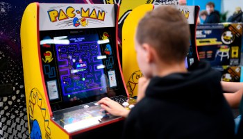 A child plays Pac-Man at a video game trade show.