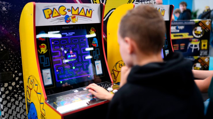 A child plays Pac-Man at a video game trade show.