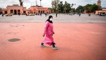 A Morrocan woman wearing a protective mask walks through the nearly deserted Jamaa el-Fna square in Marrakesh on March 17, 2020, days before Moroccan authorities implemented a strict lock down.