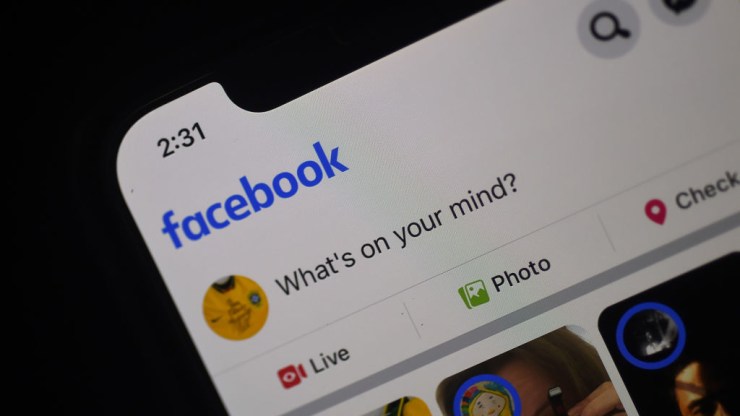 In this photo illustration a Facebook feed page is displayed on a smartphone.