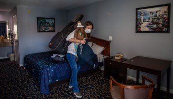 A resident gathers her belongings in a motel room provided to people needing shelter through Los Angeles' Project Roomkey.