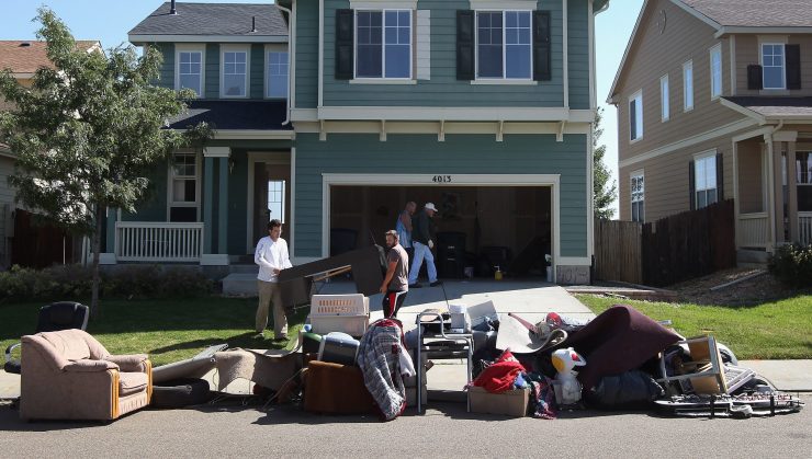 A family moving, with furniture outside a house.