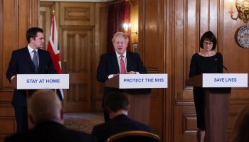 British Prime Minister Boris Johnson (center) gives a coronavirus press briefing in March. China's handling of the contagion has strained U.K.-China relations.