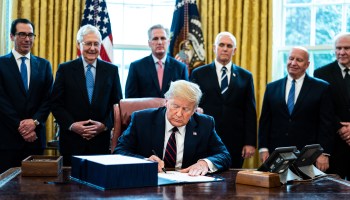 President Trump signs the CARES Act in March. Personal income rose last month mainly due to the relief payments included in the act.