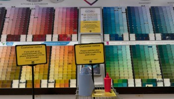 A sign asking customers to sanitize their hands before selecting a paint chip is seen at a home improvement store in London.