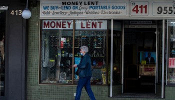 A woman wearing mask walks past a pawn shop on May 7.