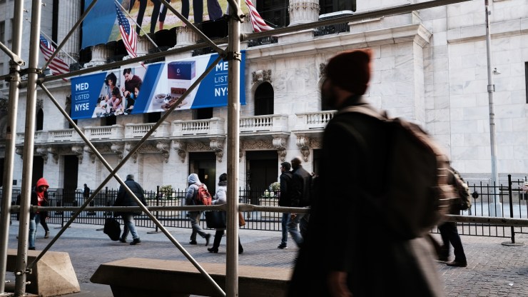 People pass by the stock exchange in New York.