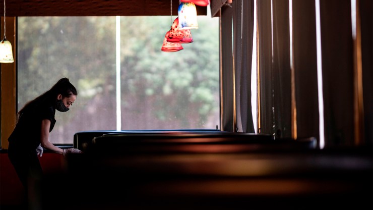 A waitress disinfects a table at a restaurant on May 5 in Stillwater, Oklahoma.