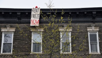 A building tenant hangs a sign from his roof in the Crown Heights neighborhood of New York City during a rent strike on May 1.