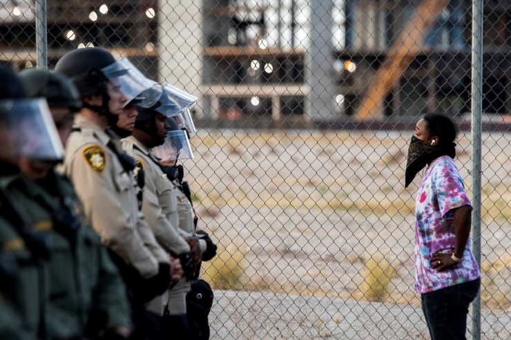 A woman stands in front of Police officers on June 1, 2020, in downtown Las Vegas, as they take part in a "Black lives matter" rally in response to the recent death of George Floyd, an unarmed black man who died while in police custody.