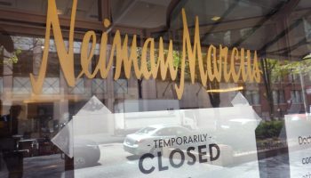 A "closed" sign in a Neiman Marcus window.