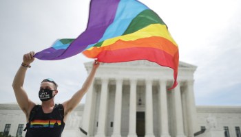An activist holds a Pride Flag outside the U.S. Supreme Court on Monday after the Court ruled LGBTQ people cannot be fired for their sexual orientation.
