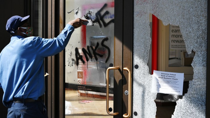 A worker cleans up a damaged bank Monday in Washington, D.C.