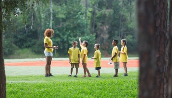 A camp counselor leads a group of kids.