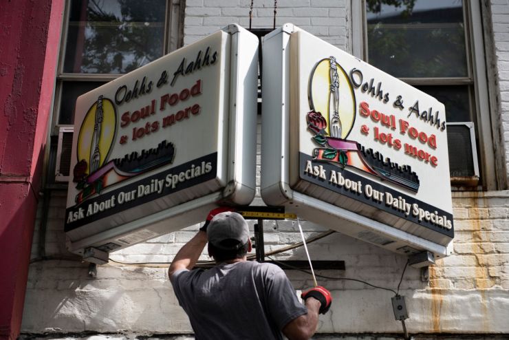A man works on the sign for Oohhs and Aahhs restaurant, one of the many on U Street in Washington, D.C.